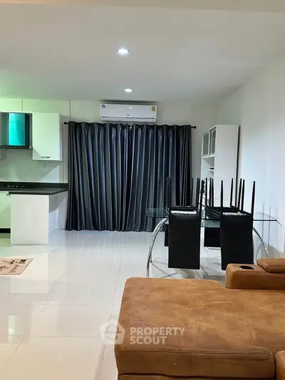 Modern living room with sleek furniture and open kitchen layout, perfect for contemporary living.