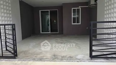 Modern residential entrance with sleek metal gate and concrete driveway