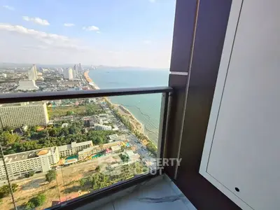 Stunning high-rise balcony view overlooking cityscape and ocean horizon.