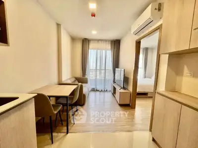 Modern apartment interior with open living and dining area, featuring sleek furniture and natural light.