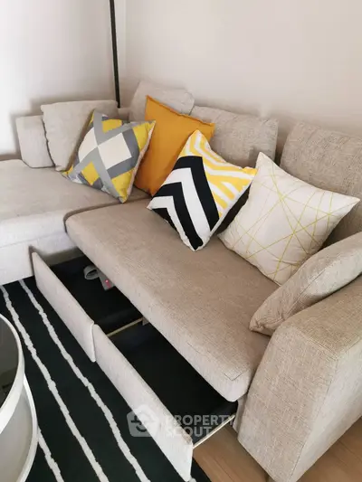 Modern living room with stylish sofa and colorful cushions, featuring hidden storage drawers for added functionality.