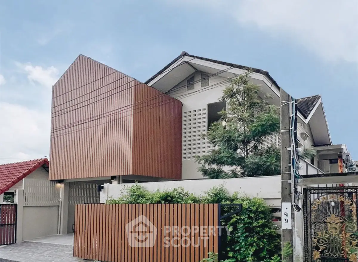 Modern architectural house exterior with unique wooden facade and lush greenery.