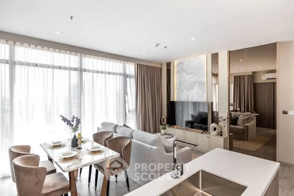 Modern open-plan living room with dining area and large windows in a stylish apartment.