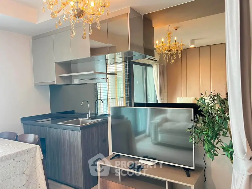 Luxurious modern living room with elegant chandelier and sleek kitchen design