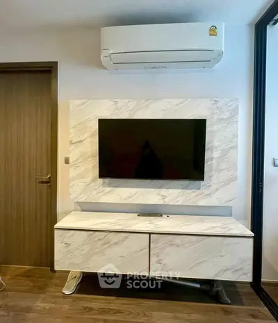 Modern living room with sleek TV setup and air conditioning unit