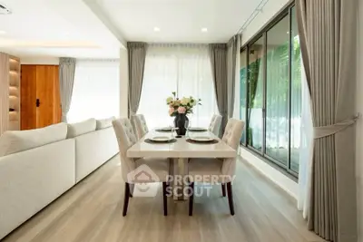 Elegant dining area with large windows and modern decor in a luxury home.
