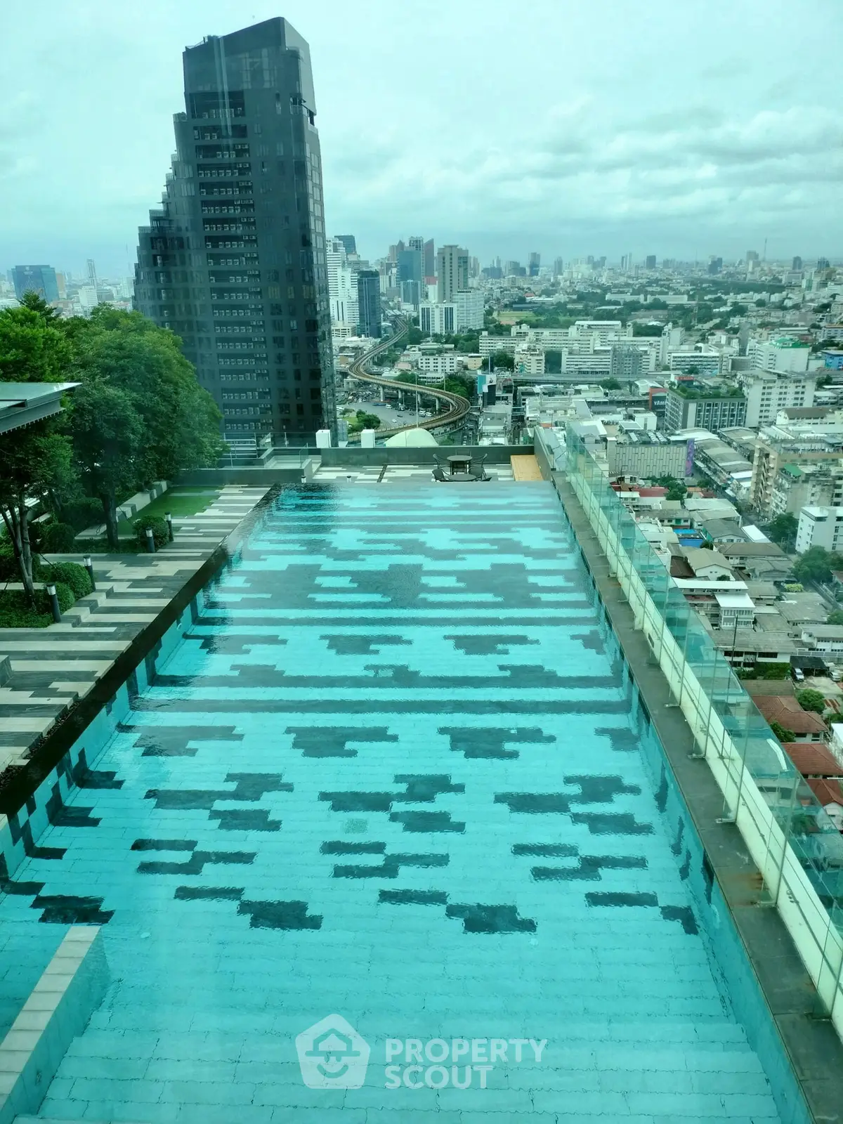 Stunning rooftop pool with panoramic city views in a modern high-rise building.