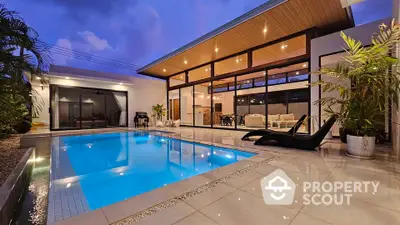 Luxurious modern home with stunning poolside view and elegant outdoor lighting.