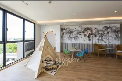 Spacious modern living room with large windows and playful children's area.