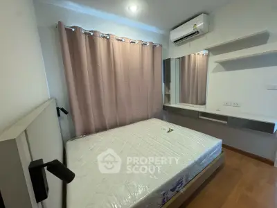 Cozy bedroom with modern furnishings and air conditioning, perfect for comfortable living.