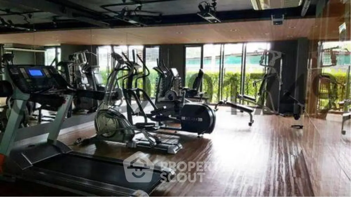 Modern gym with state-of-the-art equipment and large windows offering natural light.