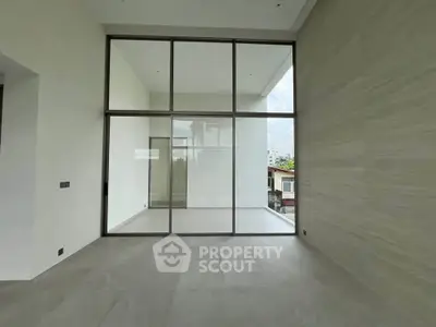 Spacious modern living room with floor-to-ceiling windows and neutral tones
