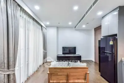 Modern living room with sleek design and natural light, featuring a cozy sofa and flat-screen TV.