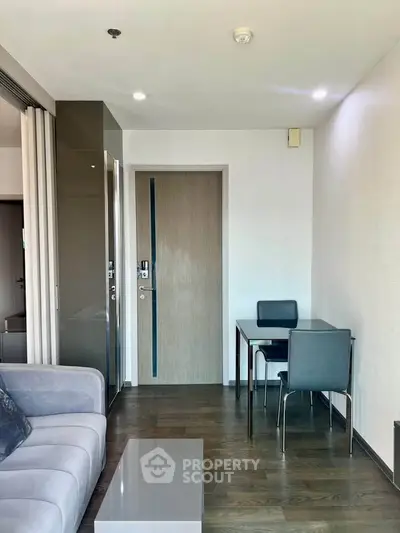 Modern living room with sleek furniture and wooden flooring in a stylish apartment.