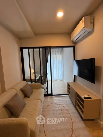 Modern living room with air conditioning and sliding glass doors leading to a bright study area.