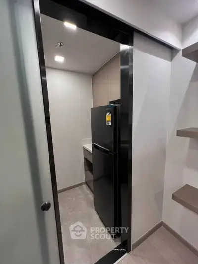 Modern kitchen with sleek black refrigerator and minimalist design