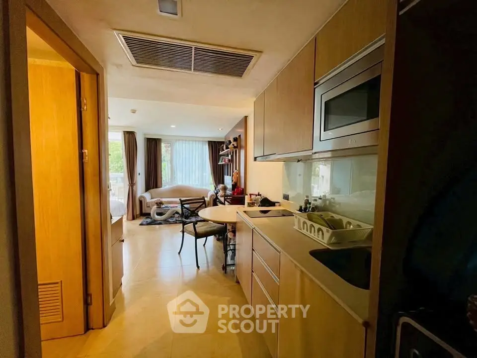 Modern open-layout kitchen with sleek cabinetry and cozy living area view.
