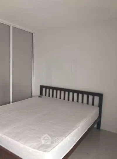 Spacious bedroom with minimalist design and large bed, perfect for relaxation.