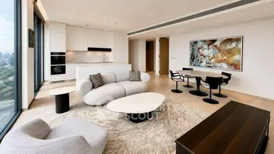 Luxurious modern living room with open kitchen and stunning city view.