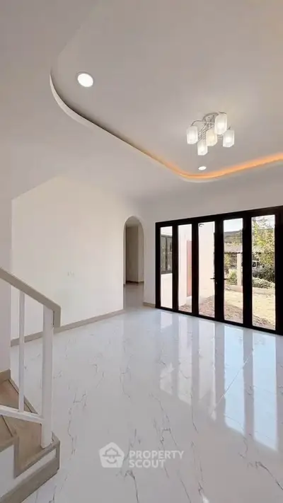 Elegant modern living room with glossy white tiles and stylish lighting, featuring large windows for natural light.