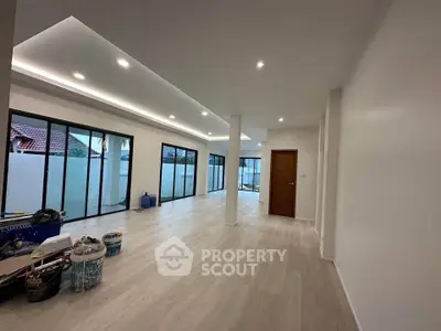 Spacious modern living room with sleek flooring and large windows for natural light.