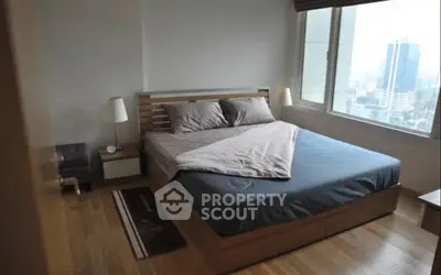 Modern bedroom with city view, featuring a stylish wooden bed and sleek decor.