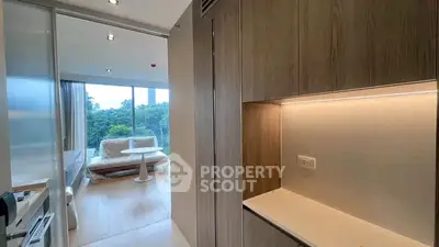 Modern apartment interior with open layout and large windows offering lush green views.
