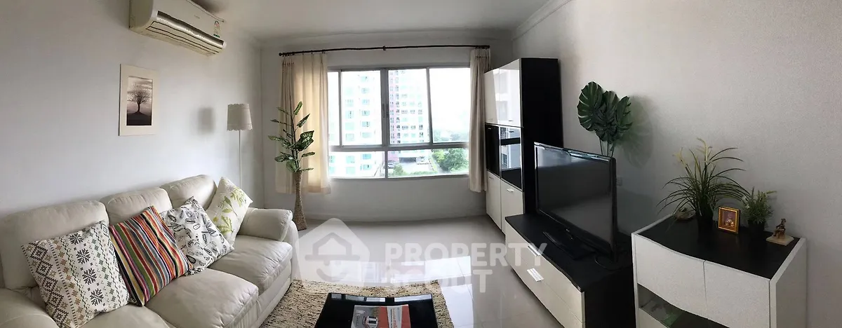 Spacious living room with modern decor and large window view