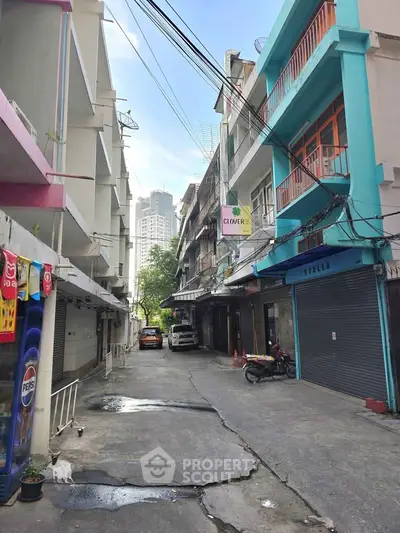 Charming urban alleyway with colorful buildings and parked vehicles, ideal for city living.