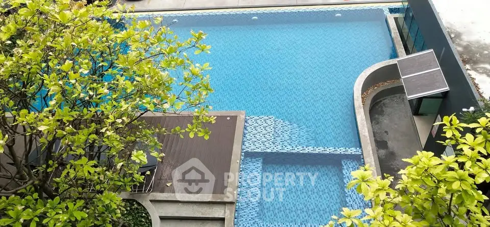 Luxurious swimming pool with modern design and lush greenery, perfect for relaxation and leisure.