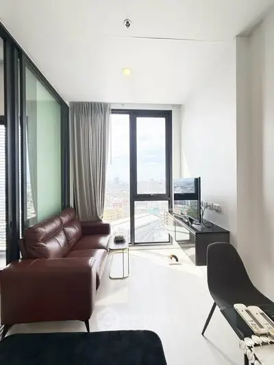 Modern living room with leather sofa and city view from large windows