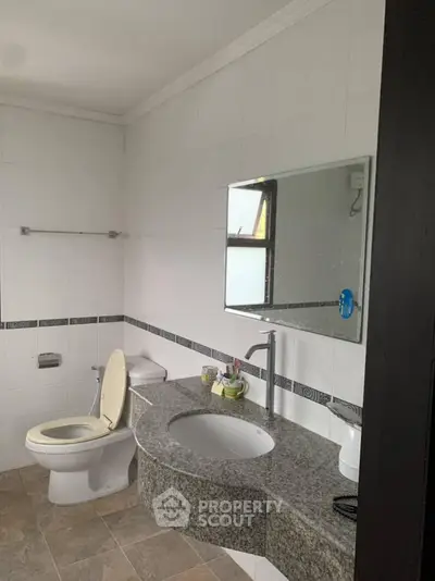 Modern bathroom with granite countertop and white tiled walls