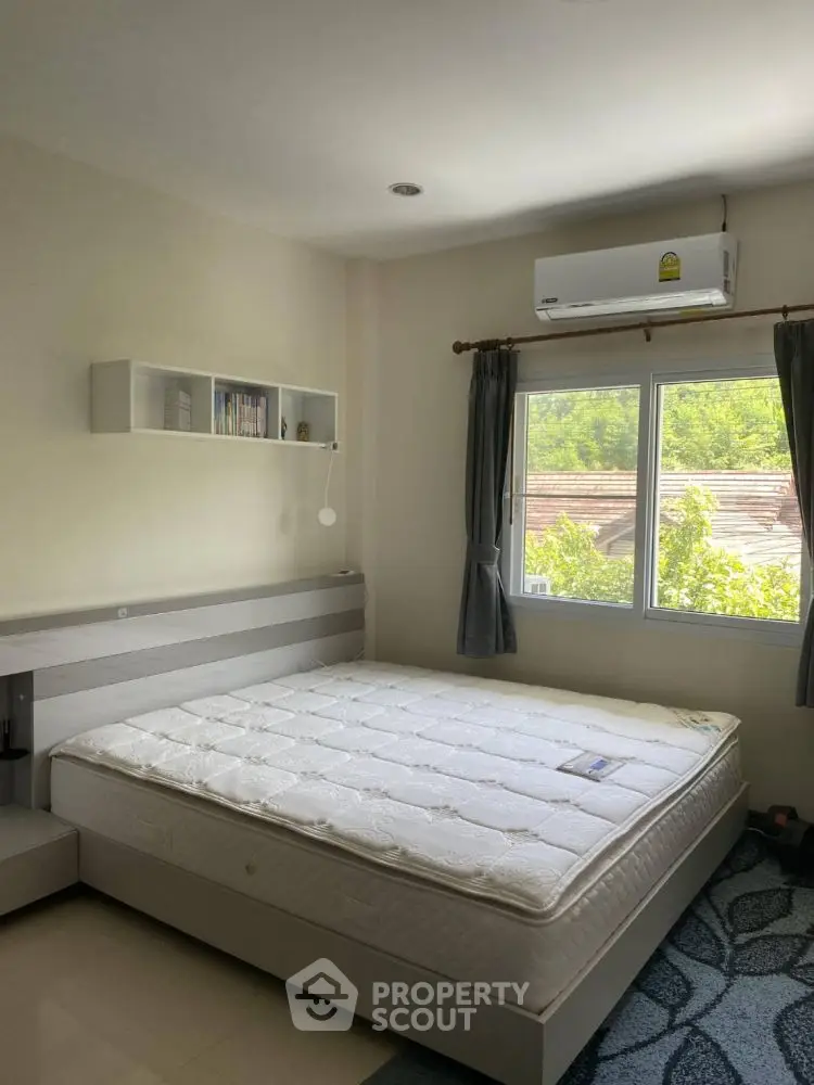 Bright and airy bedroom with large window and modern furnishings