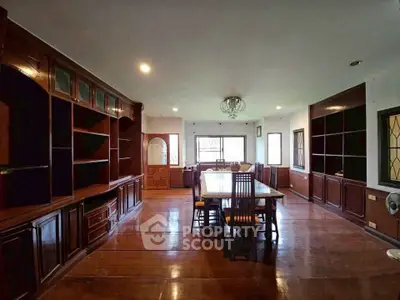 Spacious dining room with elegant wooden cabinetry and large windows for natural light.