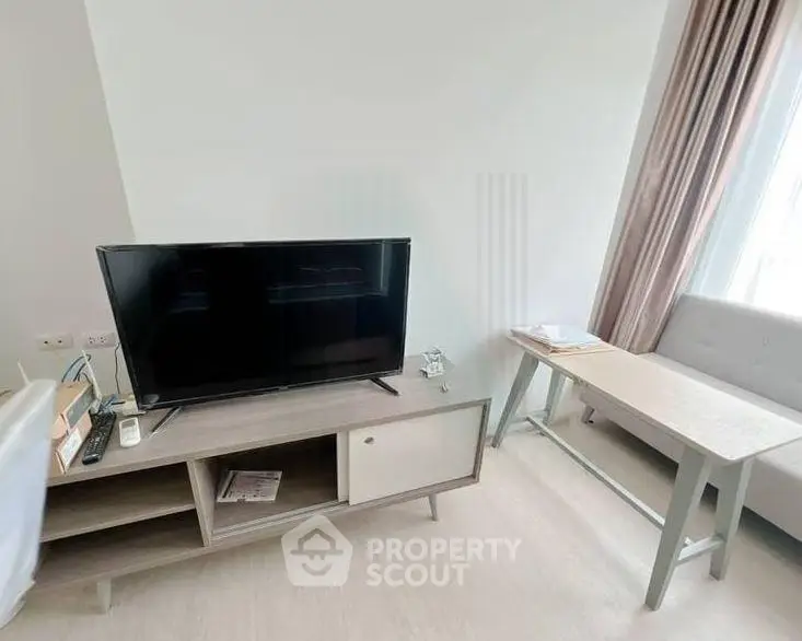 Modern living room with sleek TV stand and cozy seating area, perfect for relaxation and entertainment.