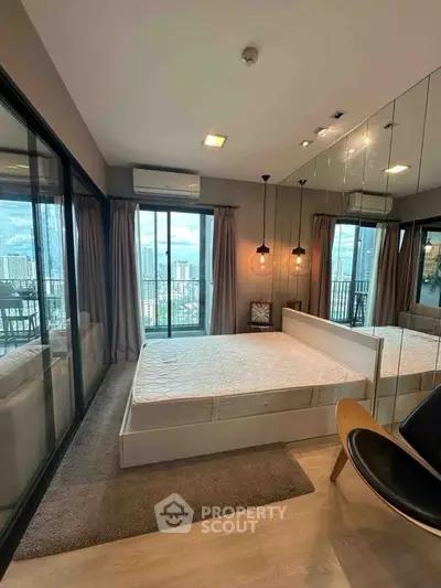 Modern bedroom with city view and mirrored wall in luxury apartment