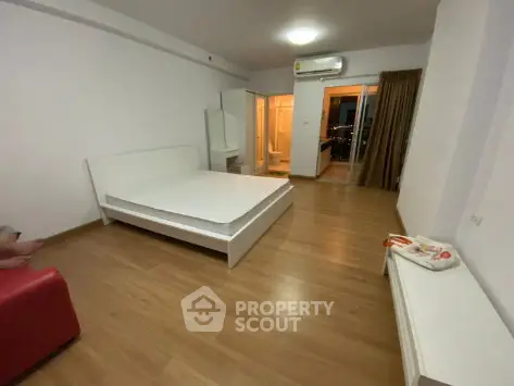 Spacious bedroom with modern furnishings and balcony access in a stylish apartment.