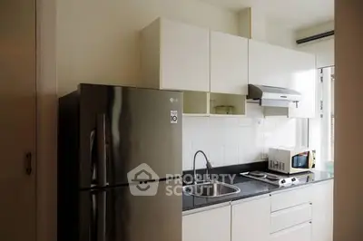 Modern kitchen with sleek appliances and ample storage in a stylish apartment.