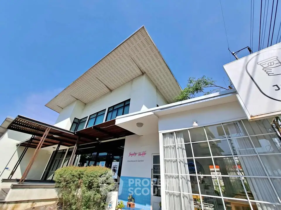 Modern building exterior with unique roof design and large windows, perfect for commercial use.