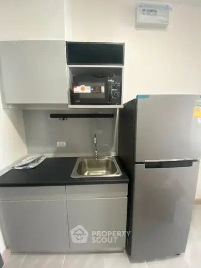 Modern compact kitchen with sleek appliances and minimalist design