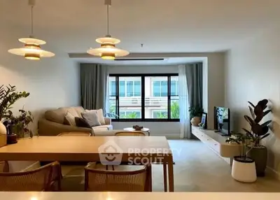 Spacious modern living room with stylish decor and large window view.
