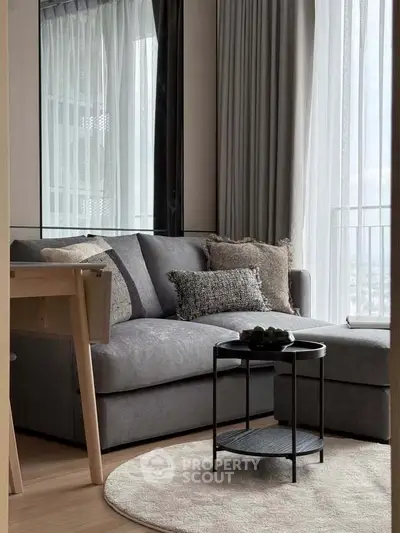Modern living room with stylish gray sofa and chic decor in a cozy apartment setting.