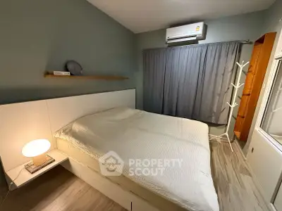 Cozy bedroom with modern decor and air conditioning, featuring a comfortable bed and stylish lighting.