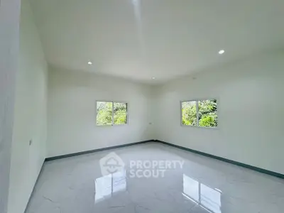 Spacious empty room with large windows and glossy tiled floor