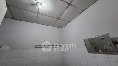 Modest bathroom with tiled walls and ceiling light fixture