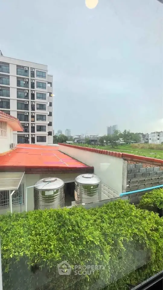 Urban view from window showcasing residential buildings and greenery