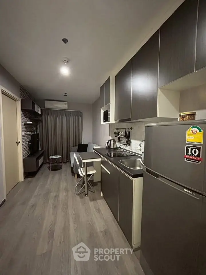 Modern apartment kitchen with sleek cabinets and cozy living area, perfect for urban living.