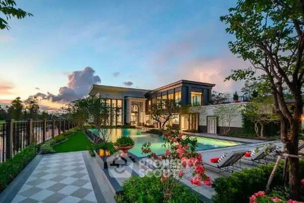 Luxurious mansion with stunning pool and garden at sunset