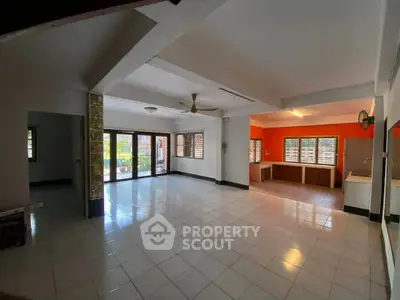 Spacious open-plan living area with large windows and tiled flooring, perfect for modern family living.