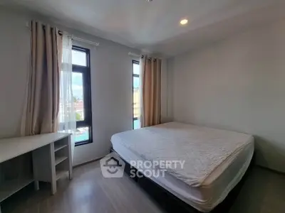 Bright and spacious bedroom with large windows and modern furnishings, perfect for relaxation.
